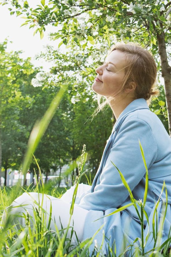 woman in blue blazer sitting on gras field